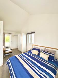 - une chambre avec un grand lit aux rayures bleues et blanches dans l'établissement Villa Tracero, à Grand Baie 16 autres photos