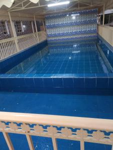 Green Resort Hotel AL khaburah في As Sarhāt: مسبح فارغ وبلاط ازرق على الارض