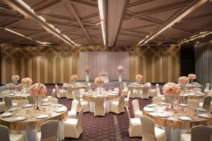 坤敬Avani Khon Kaen Hotel & Convention Centre的宴会厅配有白色的桌椅和鲜花 更多37张照片