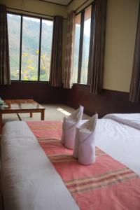 a bedroom with a bed with two white shoes on it at Thavixai Guesthouse in Nongkhiaw