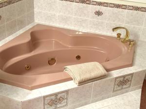 a pink bath tub with a towel in a bathroom at Spacious Room with Two Queen Sized Bed in Richmond +7 photos