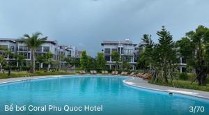 ein großer Swimmingpool vor einigen Apartments in der Unterkunft Coral Hotel Phu Quoc in Phu Quoc