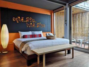 乌隆他尼维尔德豪华青旅的一间卧室配有一张大床和一张长凳