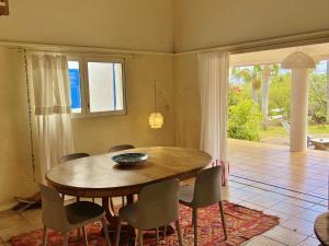 Un comedor con mesa y sillas de madera. en Villa Serenite, en F. Sauger