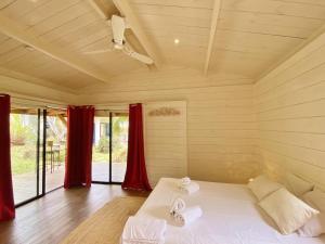 Habitación grande con cama con cortinas rojas en Villa Serenite, en F. Sauger 32 fotos más