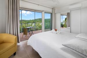 Un dormitorio con una cama grande y un balcón. en Villa Cormorans, en Saint-Gilles-les-Bains