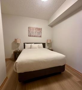 a bedroom with a large bed with two lamps at Canmore Mountain View Escape in Canmore