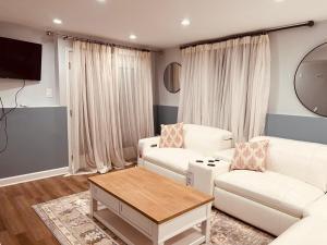 a living room with two white couches and a table at Herndon Serenity Quarters in Herndon