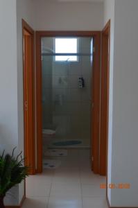 a bathroom with a shower and a glass door at Residencial Lunata in Penha