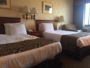 una habitación de hotel con 2 camas y una silla en Airway Inn en Queens