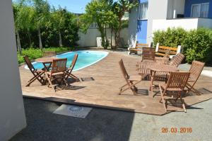 a group of chairs and tables next to a pool at Residencial Lunata in Penha