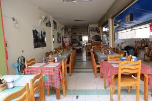 un restaurante con mesas y sillas de madera y una habitación en Pizza Italy Restaurant and Guesthouse, en Pattaya central