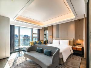 una camera d'albergo con un letto e un divano di Pullman Renhuai Chuangmeng a Zunyi