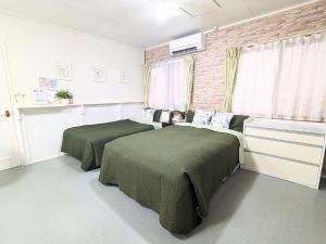 a bedroom with two beds and a brick wall at アヴェニューコザホテル in Okinawa City