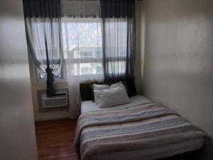 a small bed in a room with a window at seawind tower 5 family room in Davao City