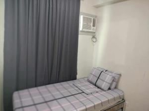 a room with a bed with a gray curtain at seawind tower 5 family room in Davao City