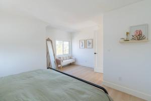 a white bedroom with a bed and a window at Grand Bend 5BR Retreat Hot Tub, Fire Pit and BBQ in Grand Bend