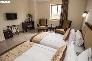 Cette chambre comprend 2 lits et une télévision. dans l'établissement Queen Plaza Hotel, à Hébron