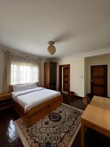 a bedroom with a large bed and a table at Logos House Nepal in Pātan