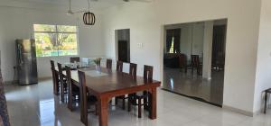 a dining room with a wooden table and chairs at Temuri Resort in Hambantota