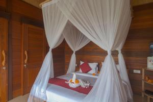Un pat sau paturi într-o cameră la Susi Villas Ubud