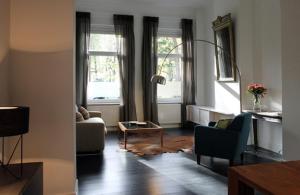 Parc Brussels Apartment في بروكسل: غرفة معيشة مع أريكة وطاولة