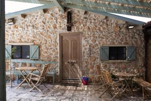 a stone building with chairs and a door at Like Home Gedera in Gedera