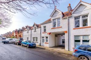 a row of houses on a street with parked cars at Classy private spacious flat in North Berwick