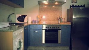 a kitchen with blue cabinets and a black refrigerator at Apartamento Loft II Select Real Caldas de Reis in Caldas de Reis