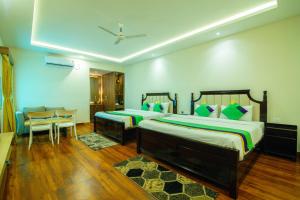 a bedroom with two beds and a table and chairs at Treebo Greenland Resort Patia in Bhubaneshwar +69 photos