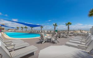 eine Gruppe von Liegestühlen und ein Swimmingpool in der Unterkunft San Carlos 1501 in Gulf Shores