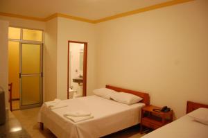 1 dormitorio con 2 camas y baño en Minas Hotel Unidade Rodovia, en Mariana