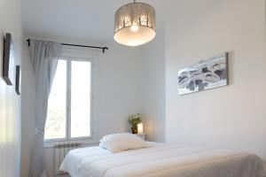 オンフルールにあるアパルトマン 3 ピエースのベッドと窓のある白い寝室