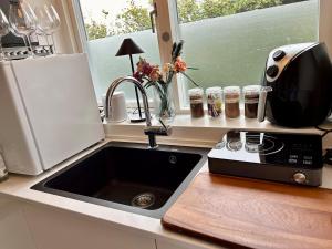 オーデンセにあるModern 3BR near Rosengård, City E20 & Congress Cのシンクと電子レンジ付きのキッチンカウンター