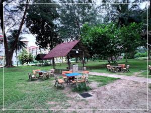 - un groupe de tables de pique-nique et de chaises dans un parc dans l'établissement Tiara Desaru Residence by UCome Homestay, à Bandar Penawar