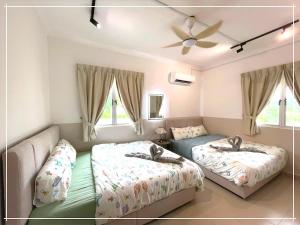 une chambre avec deux lits et un canapé dans l'établissement Tiara Desaru Residence by UCome Homestay, à Bandar Penawar 30 autres photos
