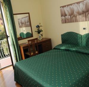 a bedroom with a bed and a table and a chair at Hotel Miranda in Varazze