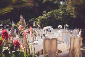 a table set up for a wedding with white tables and flowers at Hotel Villa Margherita in Quercianella