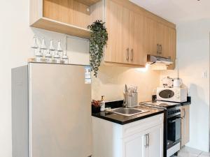 Best Staycation in BGC Central #aatft13j في مانيلا: مطبخ صغير مع ثلاجة ومغسلة