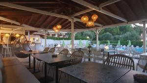 an empty restaurant with tables and chairs and lights at Palladium Hotel in Kriopigi