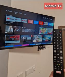a person holding a remote control in front of a tv at apartmán Meluzínka in Loučná pod Klínovcem +5 photos