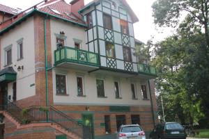 a building with a balcony on the side of it at Willa Amor in Krynica Morska