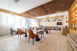 威海World Hotel Weihai International Bathing Beach Torch 8th Street Branch的一间有桌椅的餐厅