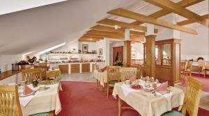 a restaurant with white tables and chairs and a kitchen at Hotel Birnbacher Hof in Bad Birnbach