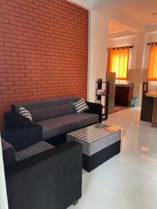 uma sala de estar com dois sofás e uma parede de tijolos em Unic Residence And Transit Hotel em Katunayaka