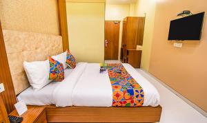 ムンバイにあるFabHotel Seven Hills - Nr Mumbai International Airportのベッド1台、テレビが備わるホテルルームです。