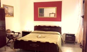 1 dormitorio con cama y espejo en la pared en B&B Historia Magistra, en SantʼAntìoco