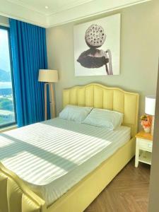 a bedroom with a yellow bed with a window at CĂN HỘ ALTARA Hương vị Biển in Quy Nhon
