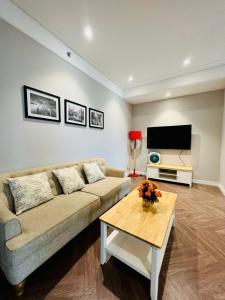 a living room with a couch and a tv at CĂN HỘ ALTARA Hương vị Biển in Quy Nhon +2 photos