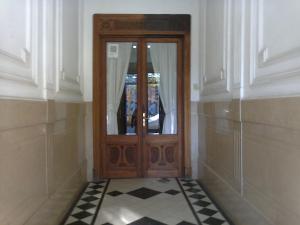 una puerta de madera en una habitación con suelo blanco y negro en Hotel Plaza Tres Arroyos en Tres Arroyos